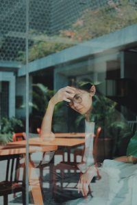 woman looking sad through a window