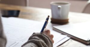 person writing at the desk - chair massage maryland