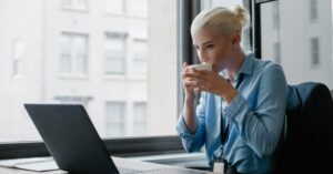 woman drinking of hot drink in her office