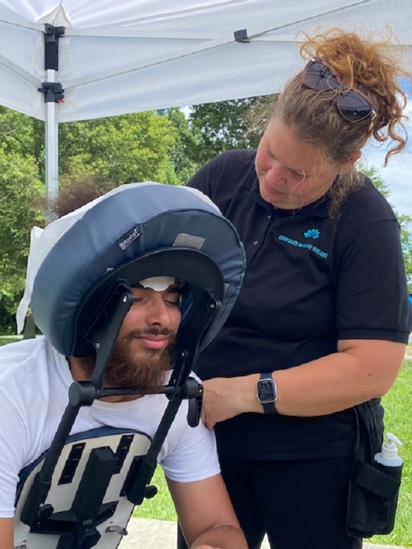 Massage therapist from Corporate Massage Kneads massage shoulders of relaxed man